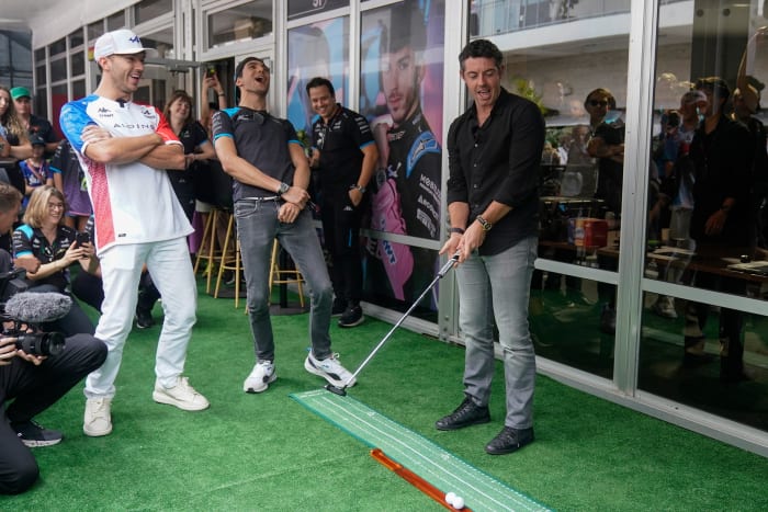 Golfer Rory McIlroy and Alpine drivers Pierre Gasly and Esteban Ocon all react to a missed putt by McIlroy before the sprint race ahead of the Formula One U.S. Grand Prix.